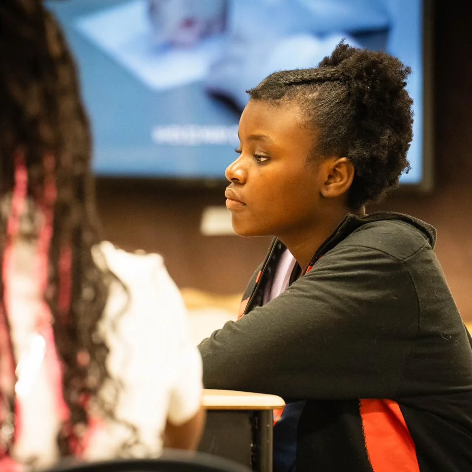 Middle School Student Helping Younger Students Write